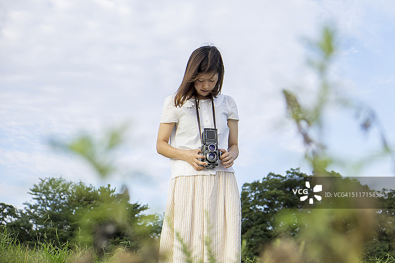 一个拿着旧相机的年轻女人图片素材