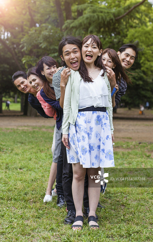 年轻人有乐趣和拥抱在城市公园，东京。图片素材