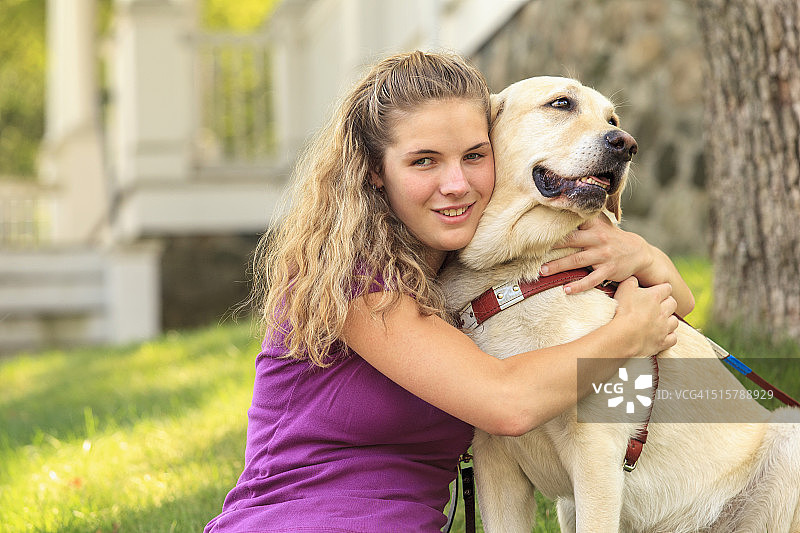 有视力障碍的女人拥抱她的服务犬图片素材