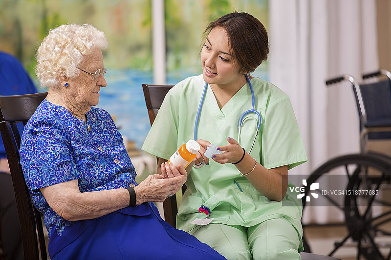 家庭保健护士向老年妇女解释处方药物。图片素材