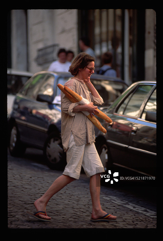 女人带着法国长棍面包图片素材