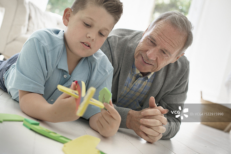 爷爷和孙子(10-12岁)在玩模型飞机图片素材