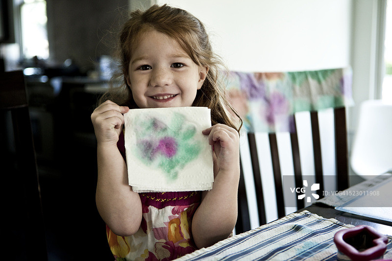 女孩(5-6)展示手工装饰的餐巾图片素材
