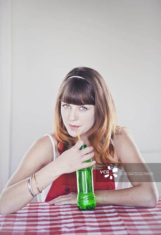 年轻女子喝苏打水的肖像图片素材