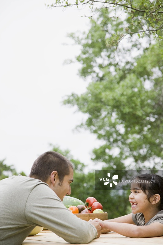 父亲和女儿坐在野餐桌上图片素材