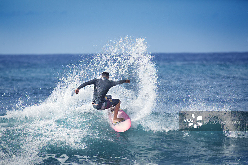 年轻男子冲浪者在夏威夷考艾岛的太平洋海浪上冲浪图片素材