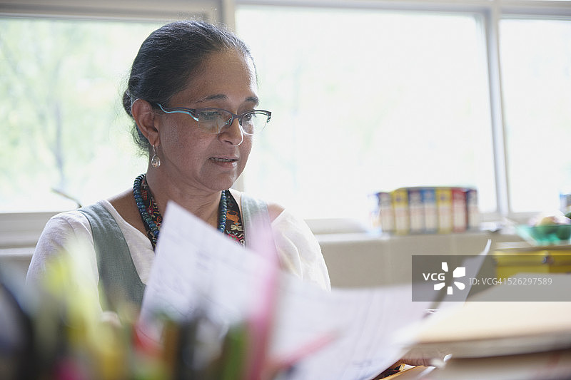 一名印度妇女在办公桌前阅读文件图片素材