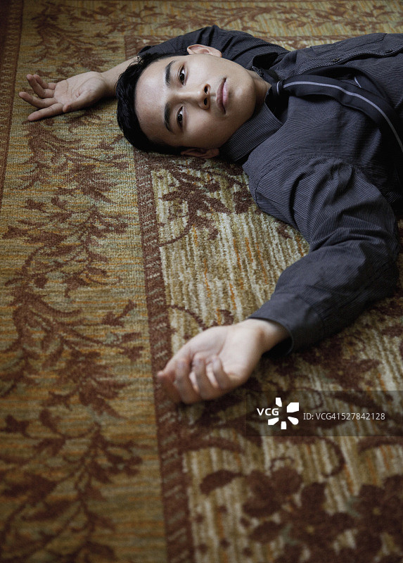 年轻人躺在地毯上图片素材