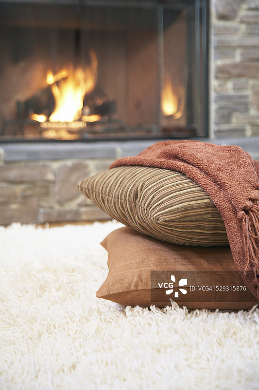 壁炉旁边的枕头和毯子图片素材