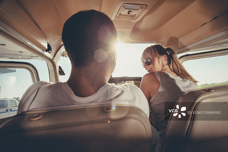 一对年轻夫妇坐在螺旋桨飞机的驾驶舱里图片素材
