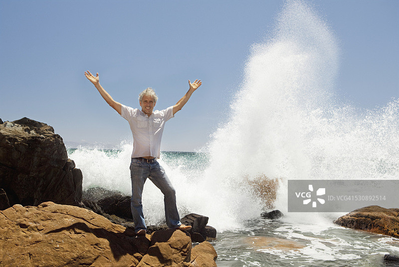 举起手臂的人被海浪溅起图片素材