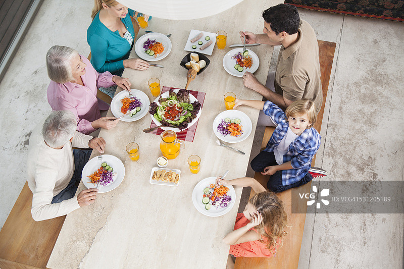 在餐桌上享用沙拉和果汁的大家庭图片素材