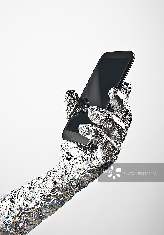 铝箔包装的手和智能手机图片素材