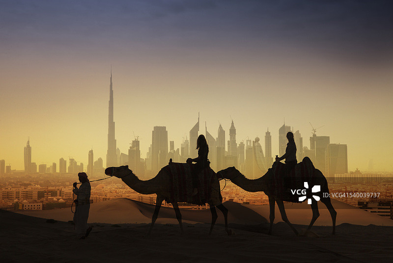 骑着骆驼观看未来城市的游客图片素材