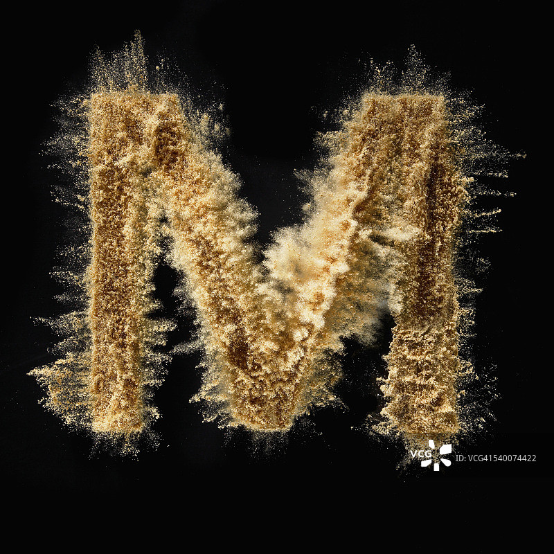 字母m的特写由沙子在黑色的背景图片素材