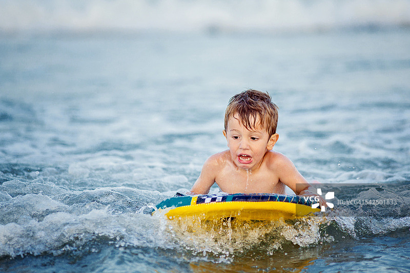 男孩在海上冲浪板上图片素材