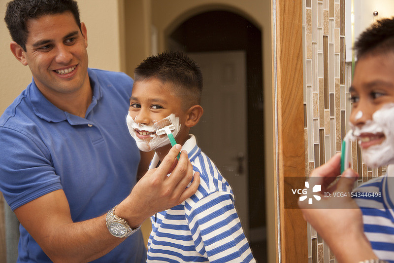家人在一起的时间!单身爸爸和儿子在家里的浴室里“刮胡子”。图片素材