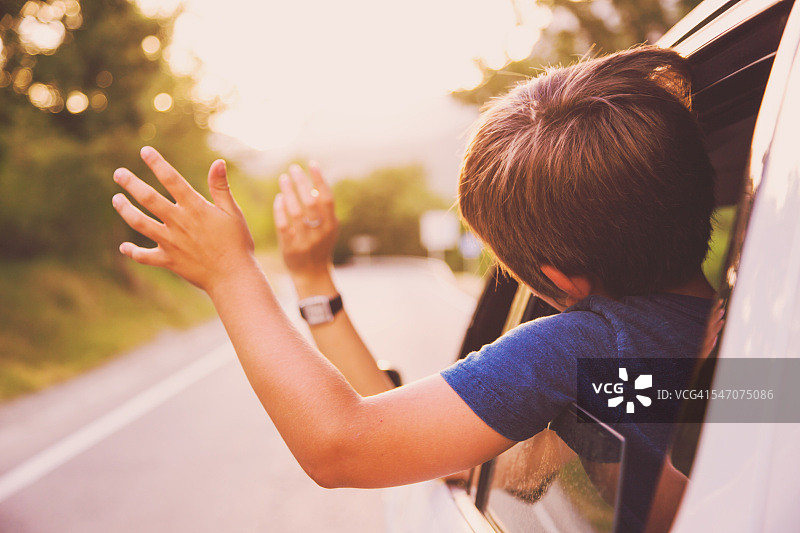 家庭夏季旅行驾驶越野车享受道路在加泰罗尼亚比利牛斯与手在道路微风。图片素材