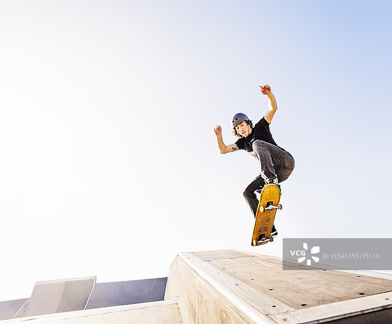 美国，佛罗里达，西棕榈滩，男子在滑板公园的滑板上跳图片素材