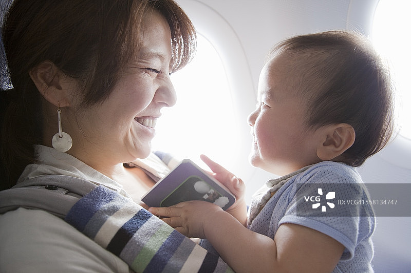 妈妈和宝宝在飞机上看书图片素材