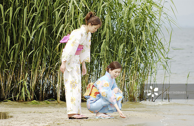 两个穿着和服的女人在湖边聊天图片素材