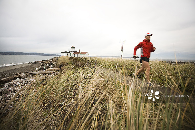 一名跑步者沿着普吉特湾在发现公园，西雅图，西澳大利亚州。图片素材