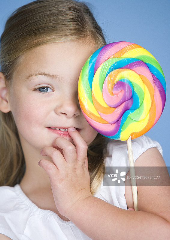 一个拿着棒棒糖的女孩的肖像图片素材