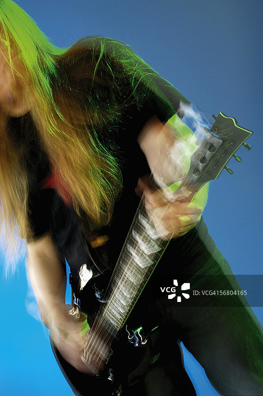 一个音乐家演奏电吉他的中间部分视图图片素材