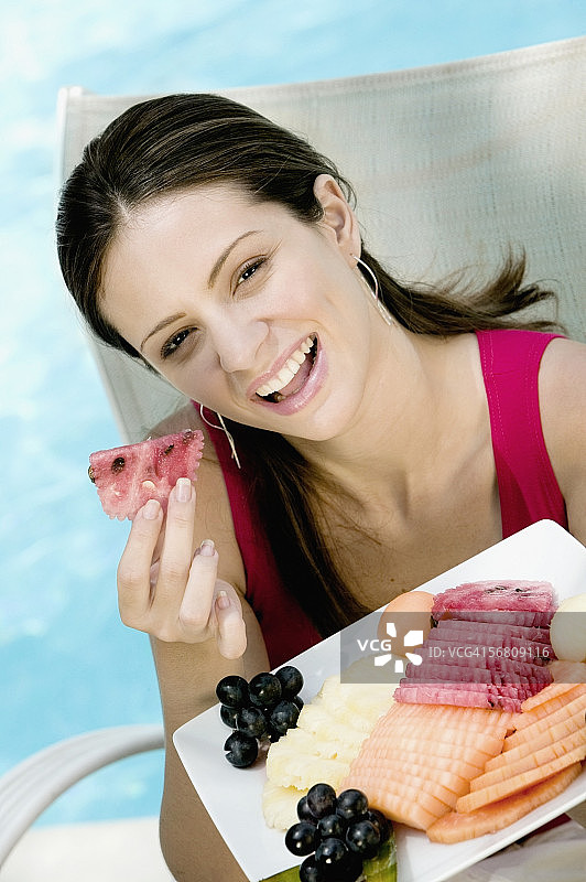 一个年轻女子吃水果沙拉的肖像图片素材