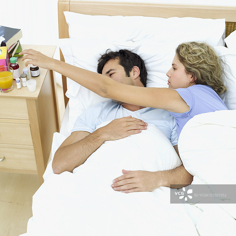 一对年轻夫妇躺在床上图片素材