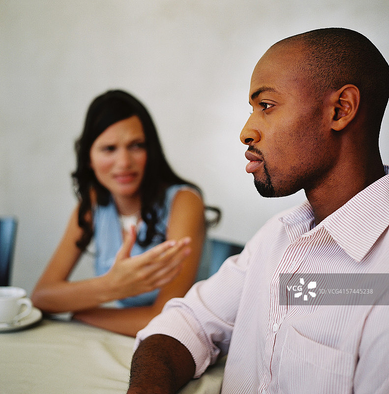 一对年轻夫妇坐在餐桌旁聊天图片素材