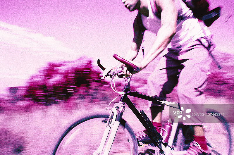 一个年轻人在野外骑自行车的低角度特写(红外线)图片素材