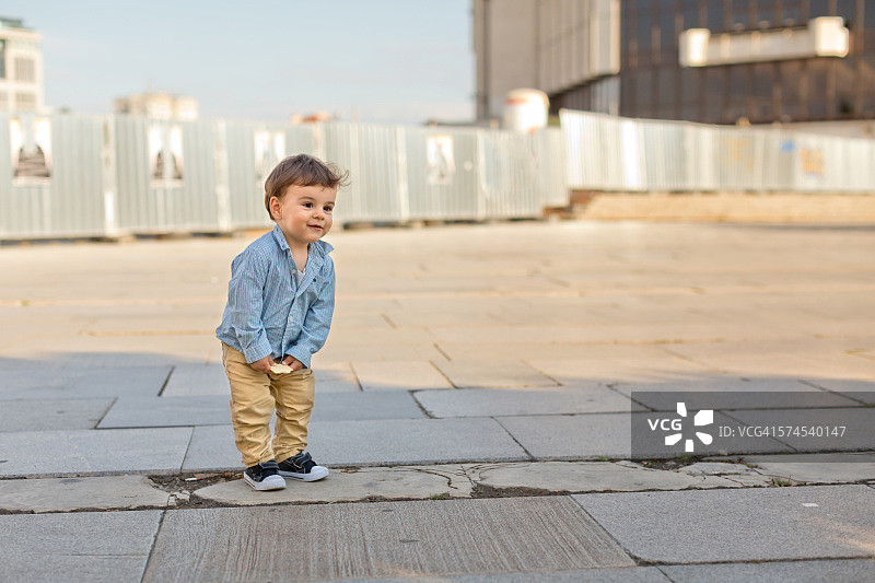 户外肖像的蹒跚学步的男孩弯曲向前图片素材