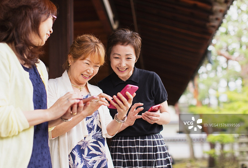 在手机上看图片的日本年长女性图片素材