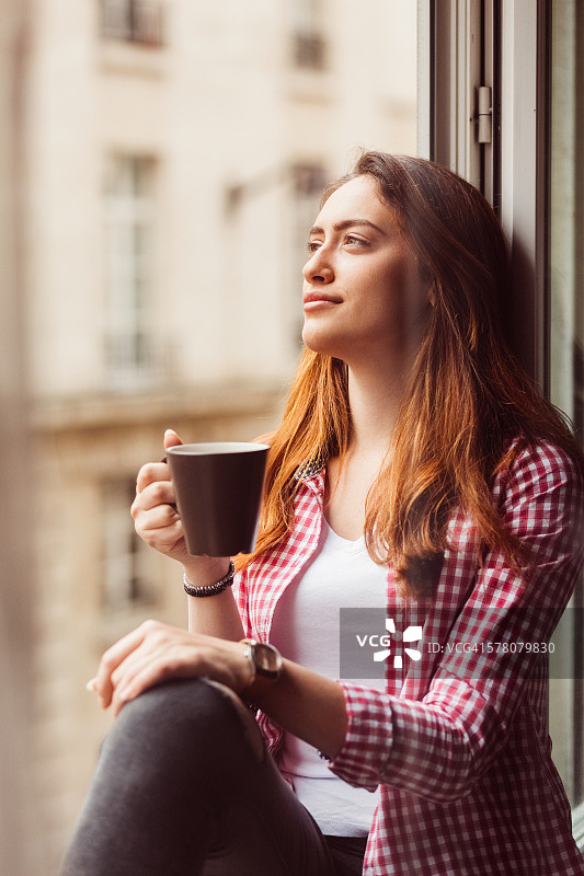 悠闲的女人在窗边喝咖啡图片素材