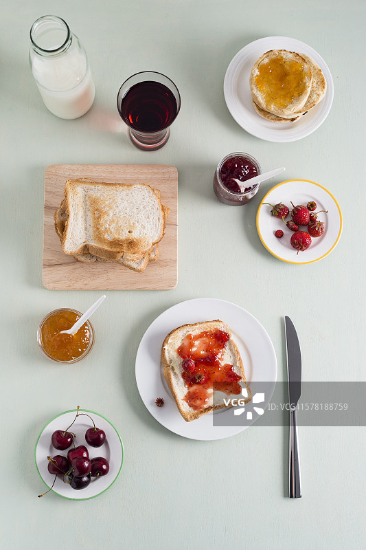 烤面包配草莓酱，烤面包配杏酱，草莓和樱桃，牛奶瓶图片素材