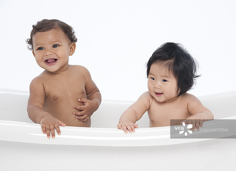 快乐的中国和西班牙婴儿在洗澡图片素材