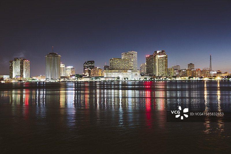 美国，新奥尔良，市中心的倒影在夜晚的密西西比河上图片素材