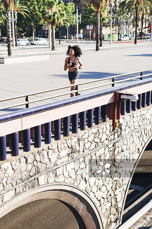 西班牙，巴塞罗那，在城市里慢跑的年轻女子图片素材