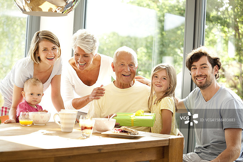 幸福的大家庭肖像与礼物在早餐桌上图片素材