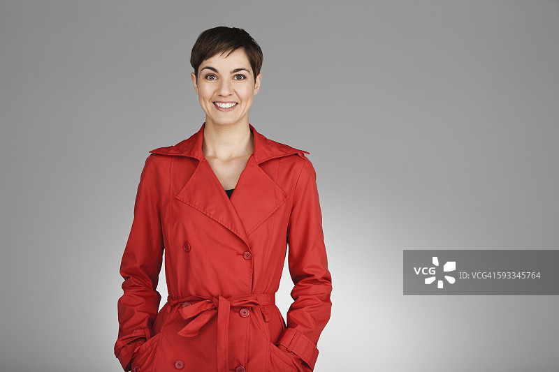 穿着红色外套的中年妇女的工作室肖像图片素材