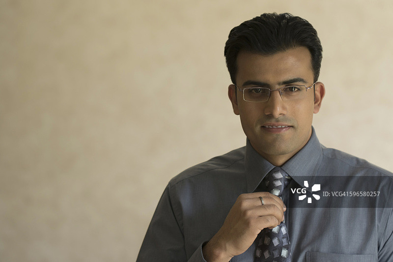 印度，年轻商人调整领带的肖像图片素材