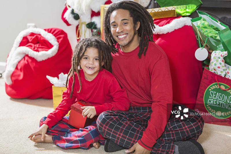 父亲和年幼的儿子在圣诞节梳着发辫图片素材