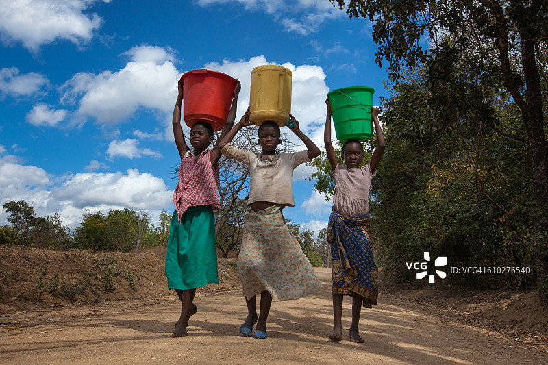 马拉维，女孩们在打井时提着水桶图片素材