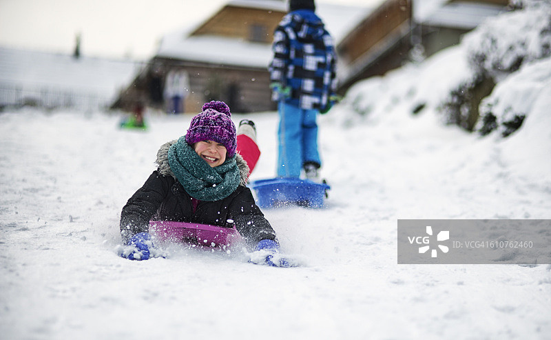 孩子们在冬天玩雪橇或雪橇。图片素材
