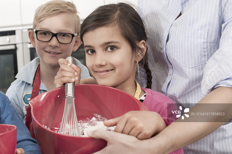 “德国巴伐利亚，家政课上，老师和学生用打蛋器在搅拌碗里打奶油”图片素材