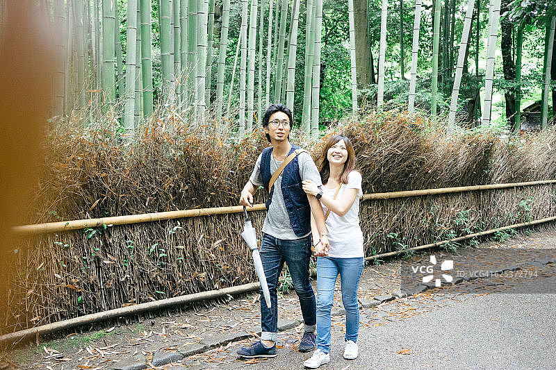 欢快的日本夫妇走过竹林图片素材