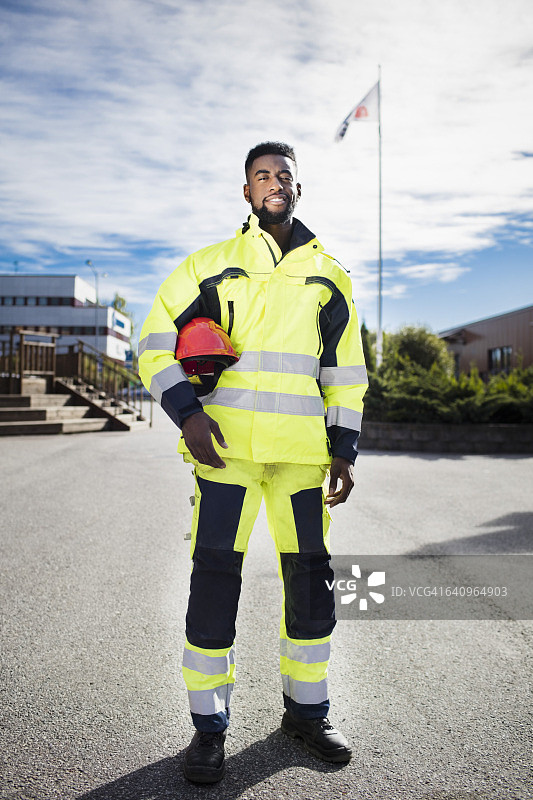 全身肖像自信的汽车技工学生穿着反光夹克户外图片素材