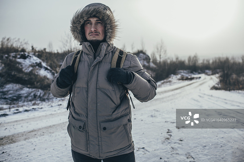 体贴的徒步旅行者背着背包站在积雪覆盖的风景图片素材
