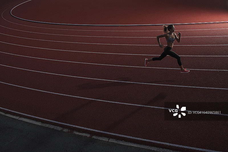 高角度的年轻女运动员在跑道上跑步图片素材